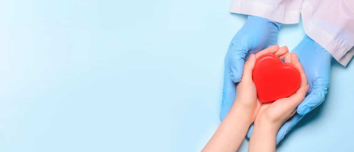 Mains de médecin et d'un patient qui tiennent un coeur