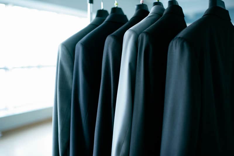 Vestes de costumes déposées sur des cintres