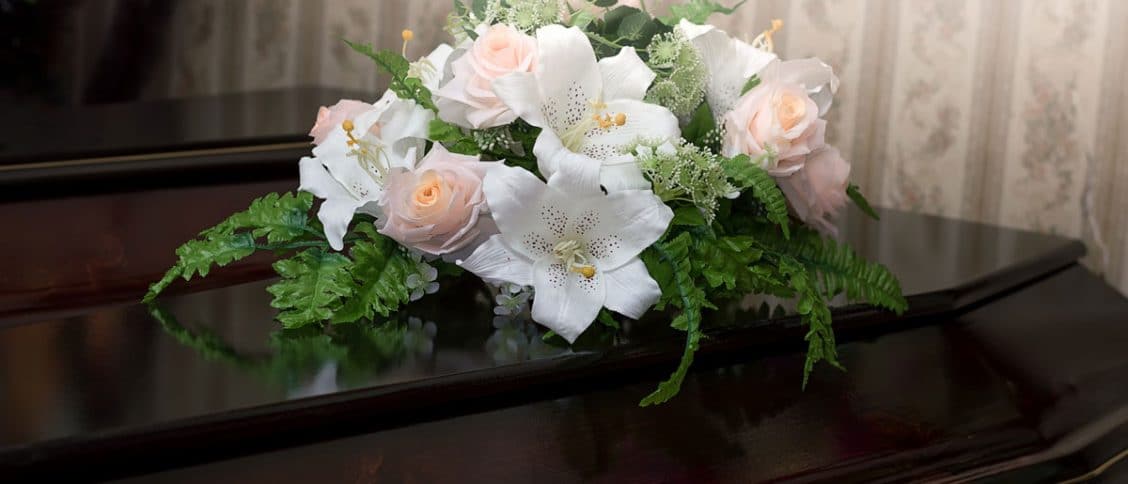 Cercueil accompagné de fleurs