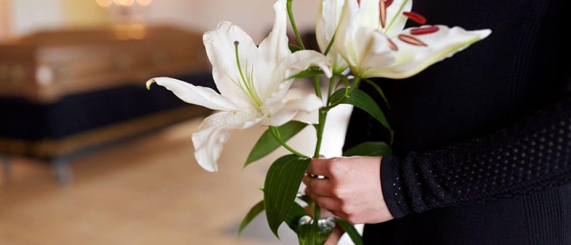 Femme qui tient des fleurs lors d'une cérémonie de funérailles