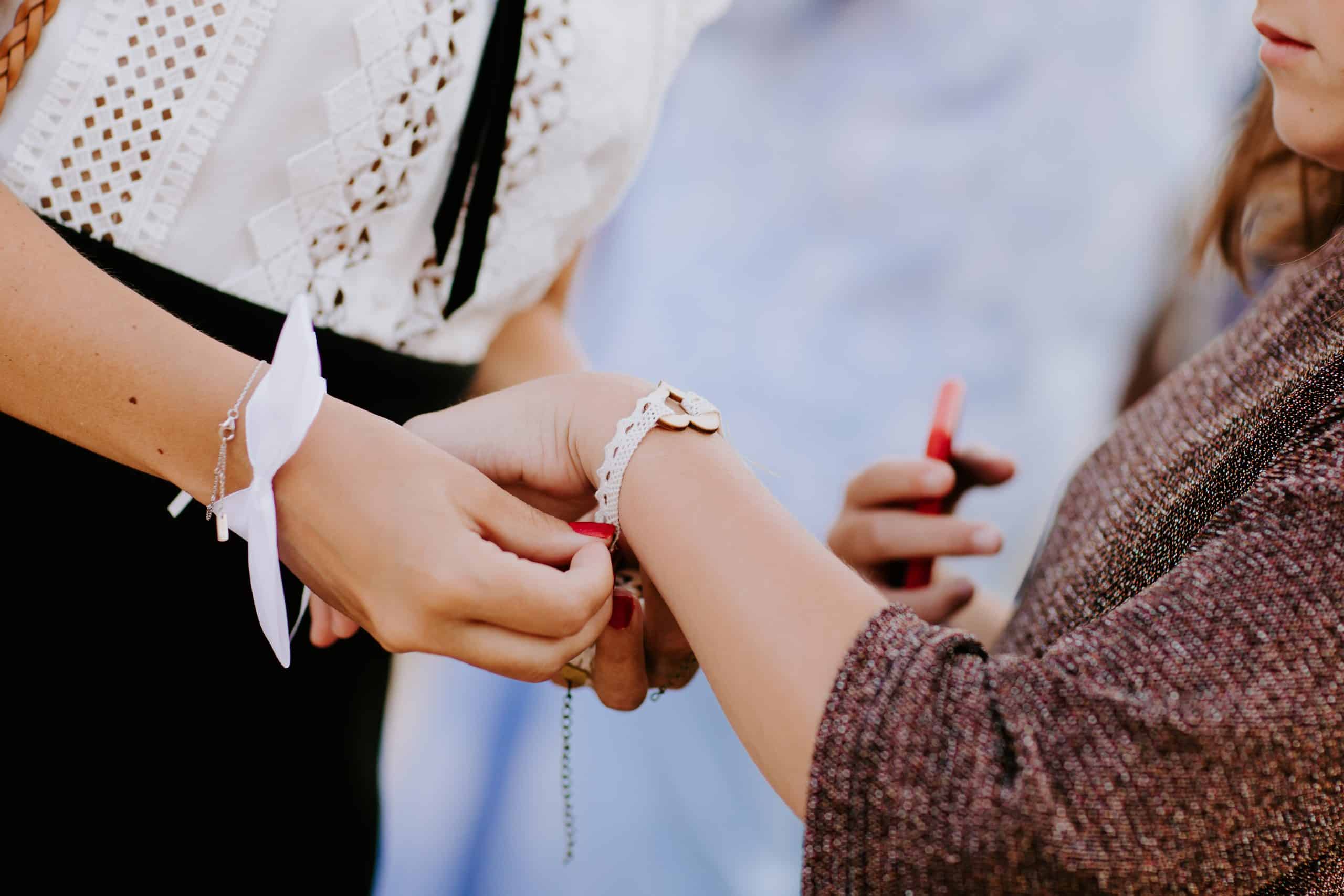 Personne accrochant un bracelet au poignet d'un proche.