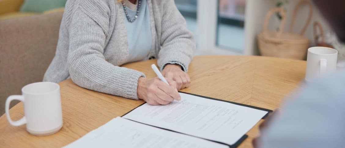 Personne signant un contrat d'obsèques.